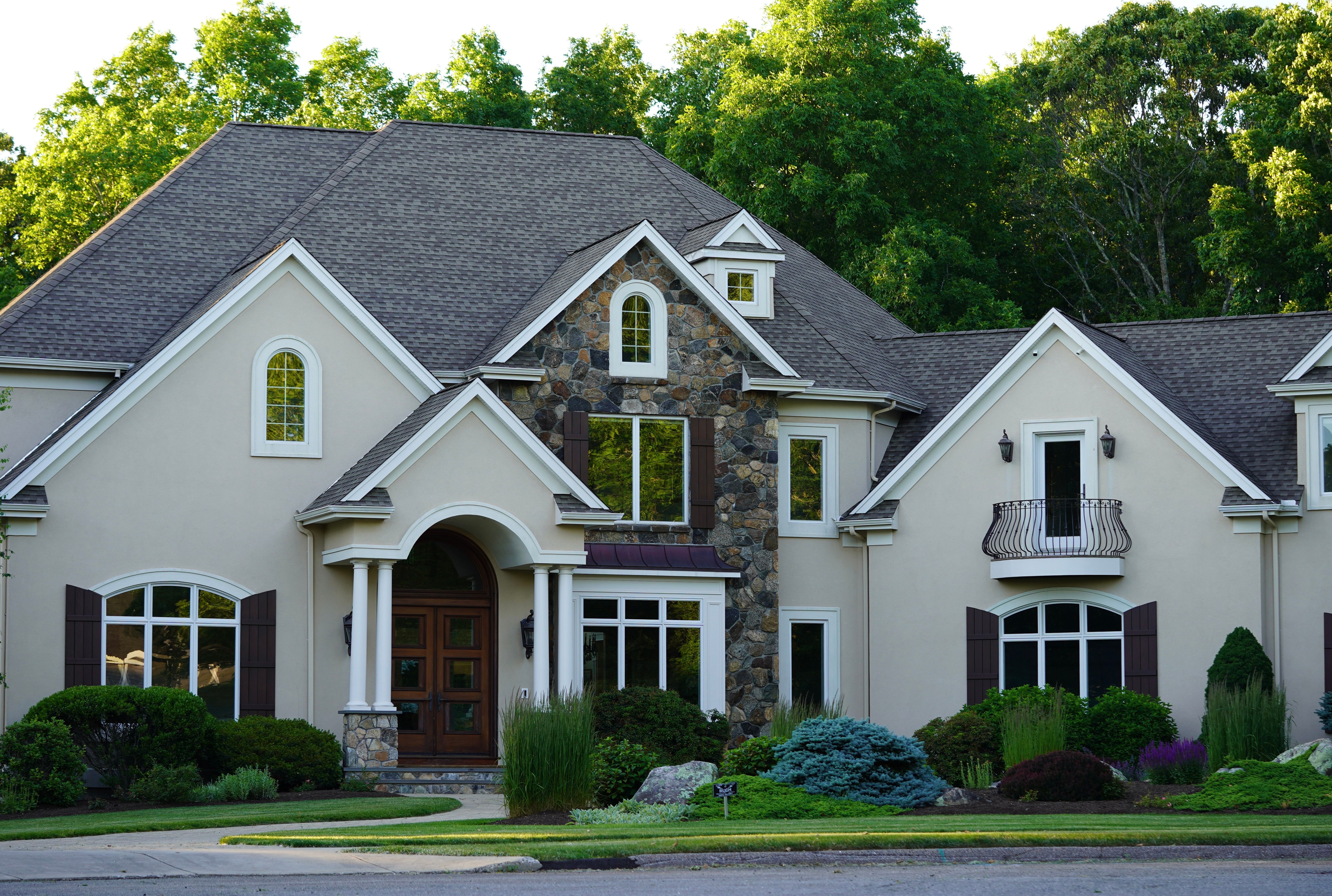 white painted concrete exterior home with stone detail
